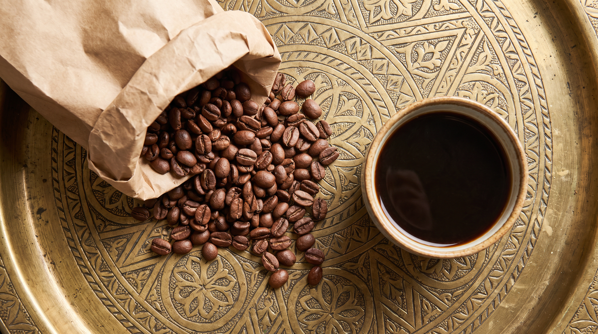 Grains de café arabica torréfaction médium et tasse de café sur un plateau marocain